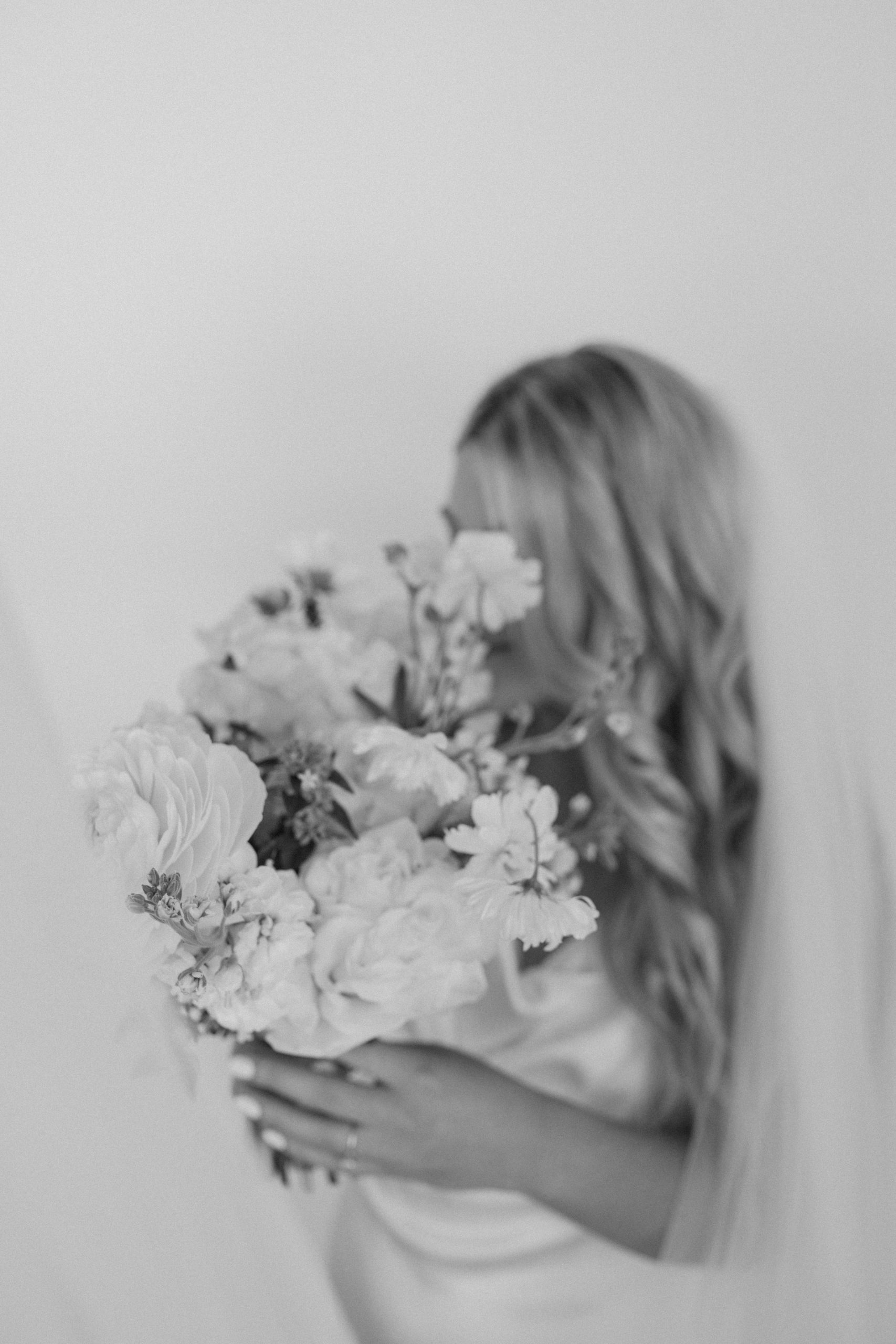 Black and white photo of bride with flowers